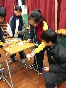S.1 student participating in a STEM activity during the short assembly